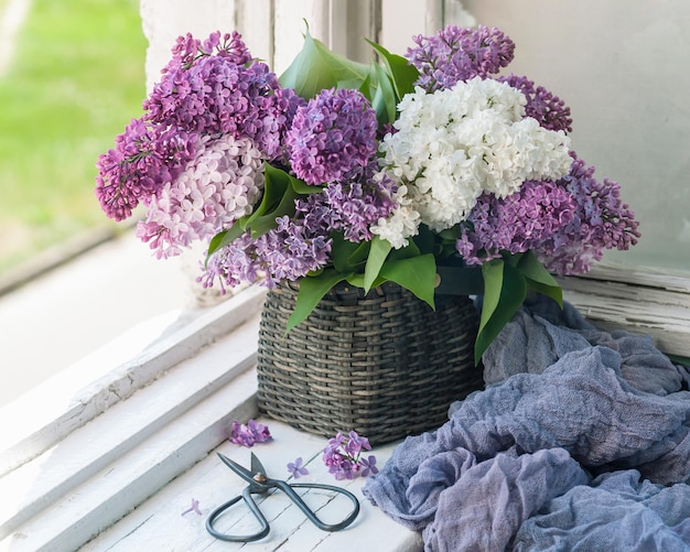 A bouquet of lilacs old envelopes and scissors on the old windowsill selective focus