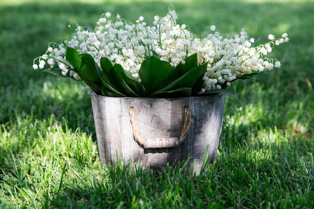 バスケットの谷のユリの花束。あなたのテキストのための場所と花の背景