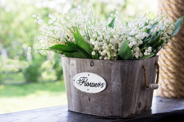 Bouquet of lilies of the valley in a basket. floral background with places for your text