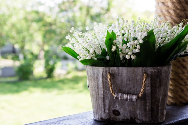 Bouquet of lilies of the valley in a basket. floral background with places for your text