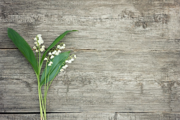 Bouquet of lilies of the valley on a wooden background. 