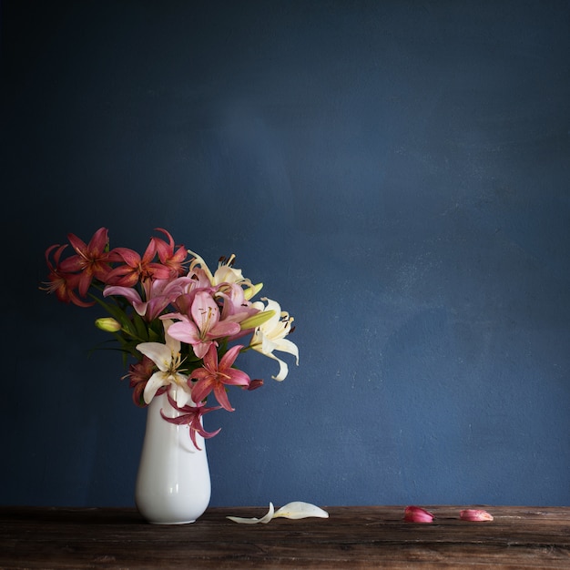 Bouquet of lily flowers in vase on dark