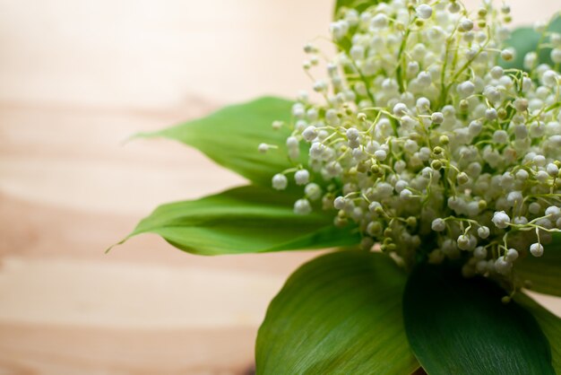 Bouquet of lily of the valley flowers on a wooden table