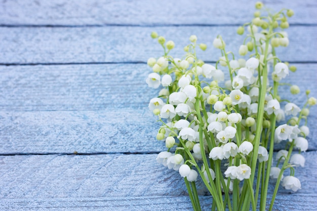 木製の背景に谷のユリの花束