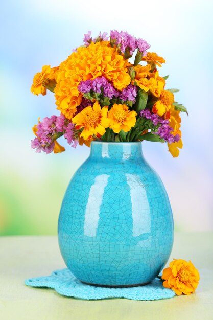 自然な背景の木製テーブルに花瓶のマリーゴールドの花の花束