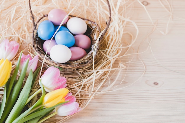 Bouquet near basket with eggs