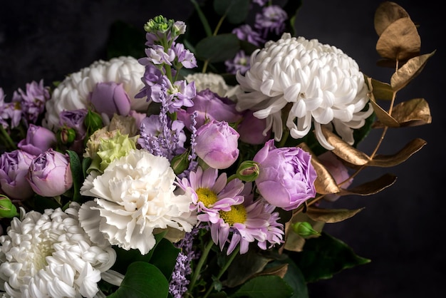 写真 別の花と黄金の装飾的な葉の花束