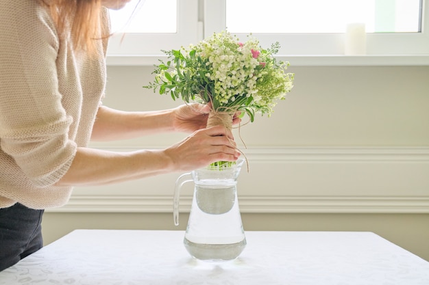 写真 新鮮な春の花の花束、女性の花束を持って、テーブルの上に花瓶に配置