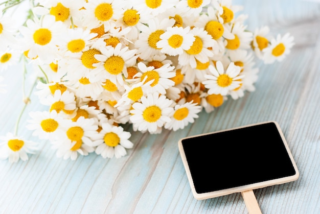 写真 木製の背景に新鮮なカモミールの花の花束