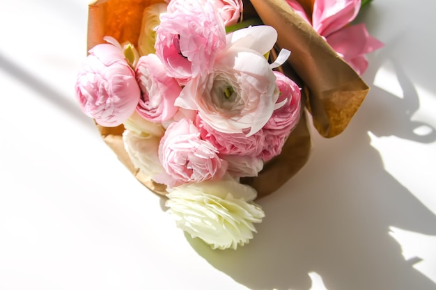 写真 ラナンキュラスの美しい繊細な花の花束花の装飾明るい日光と白い表面の影