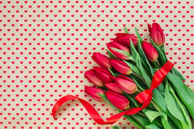 Фото Букет из красных тюльпанов на фоне сердца.