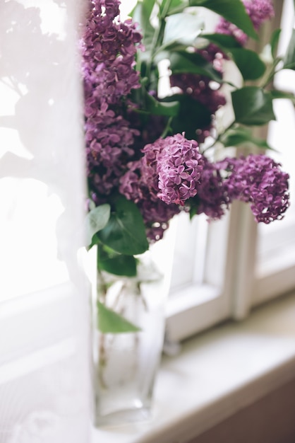 写真 花瓶に紫のライラックの花束