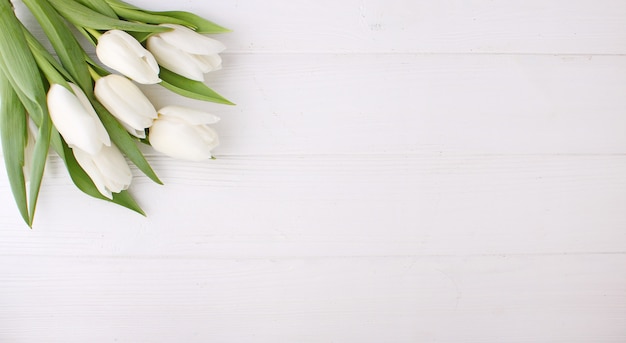写真 白い木製のテーブル、コピースペースに白いチューリップの花束。イースター。
