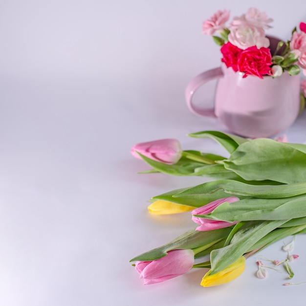 Фото Букет из желтых и розовых тюльпанов на белом фоне. чашка с цветами. день святого валентина и фон дня матери.