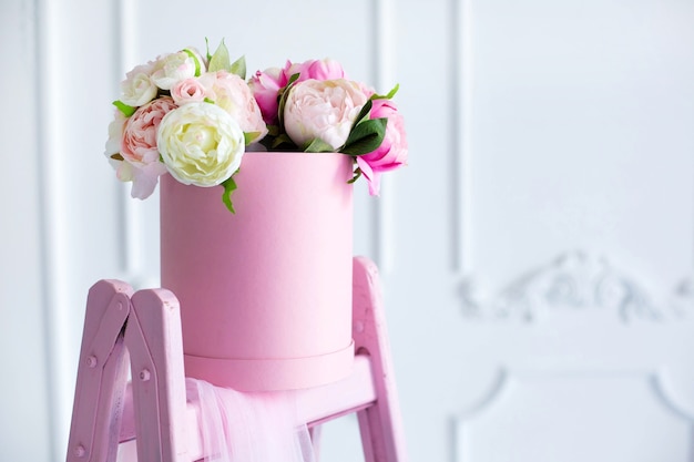 a bouquet of peonies in a beautiful pink box