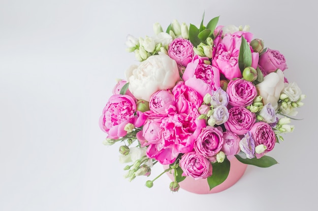 Bouquet di peonie, eustoma, spray rose in una scatola rosa