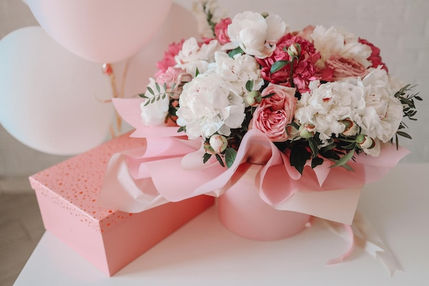 Bouquet of peonies and gift pink box birthday concept