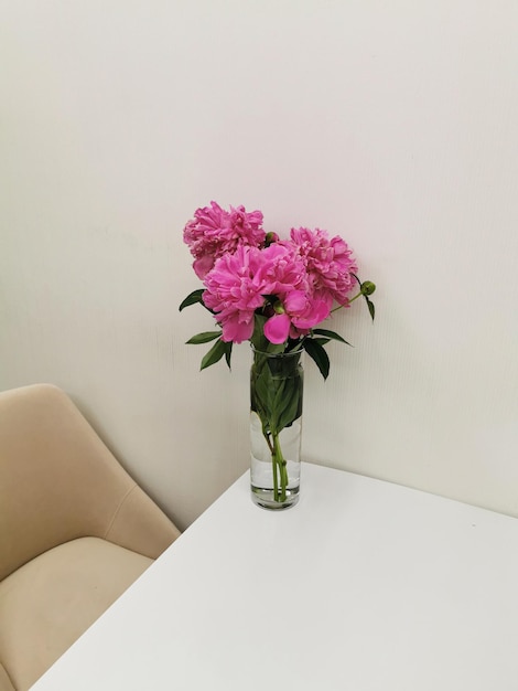 Bouquet of peony in a glass vase on the table