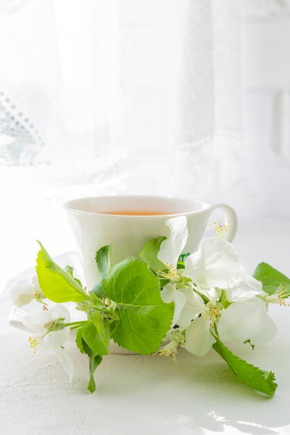 Bouquet of pink flowers (roses) and white service on a windowsill.