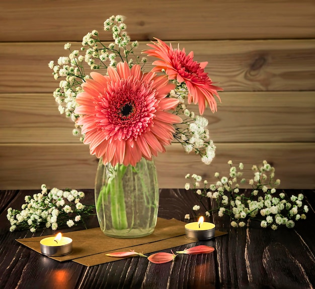 Foto bouquet di gerbere rosa in un vaso di vetro gypsophila fiori candele buste petali di fiori