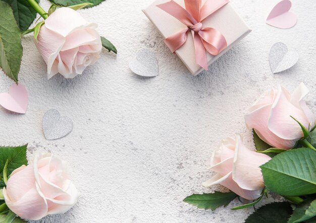 Bouquet of pink roses and gift box on a concrete background valentines day