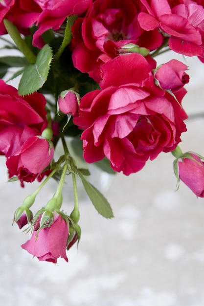 Bouquet of pink roses in a transparent vase on a wooden background for Mother's Day