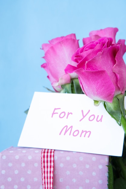 Bouquet of pink roses in vase with pink gift and mothers day card