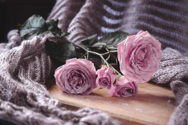 A bouquet of pink roses on a wooden table.