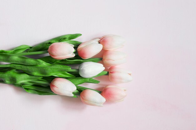 Bouquet of pink tulips on a light wooden painted background