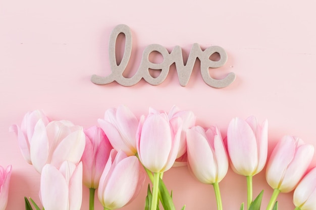 Bouquet of pink tulips on a pink background.