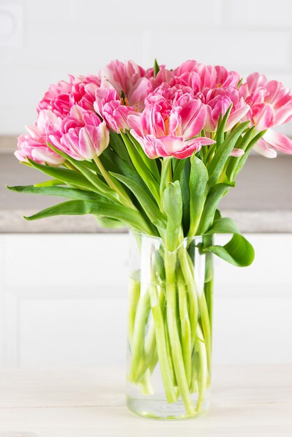 Bouquet of pink tulips in a vase on the table