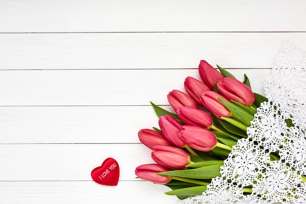 Bouquet of pink tulips on white wooden background. Valentines Day concept. 