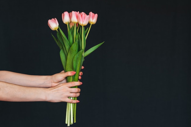 Bouquet of pink tulips in a woman's hand