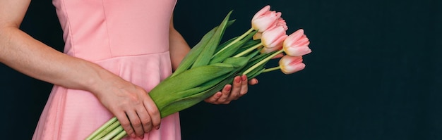 女性の手にピンクのチューリップの花束