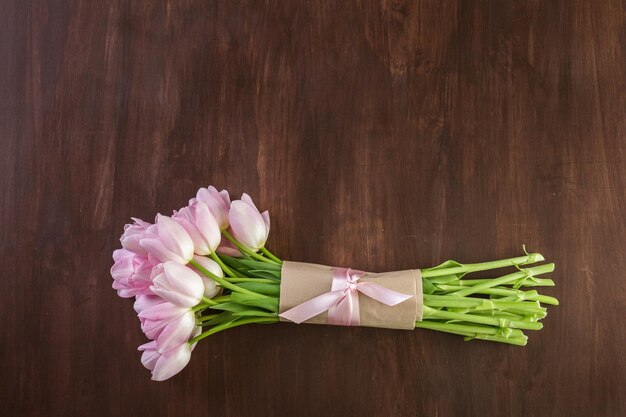 Bouquet of pink tulips on a wood background.