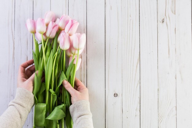 Bouquet of pink tulips on a wood background.