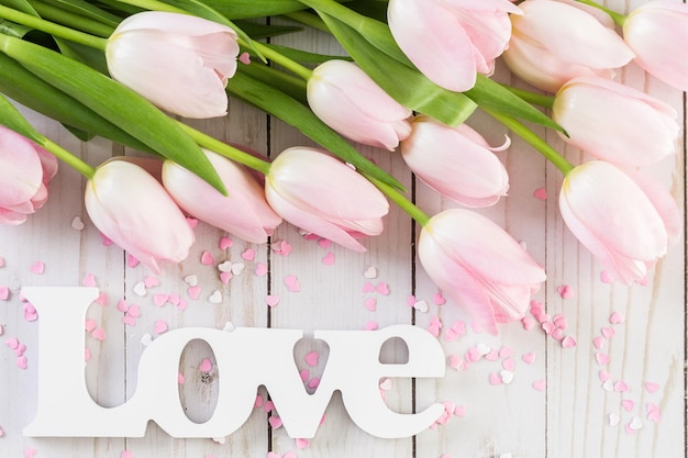 Bouquet of pink tulips on a wood background.