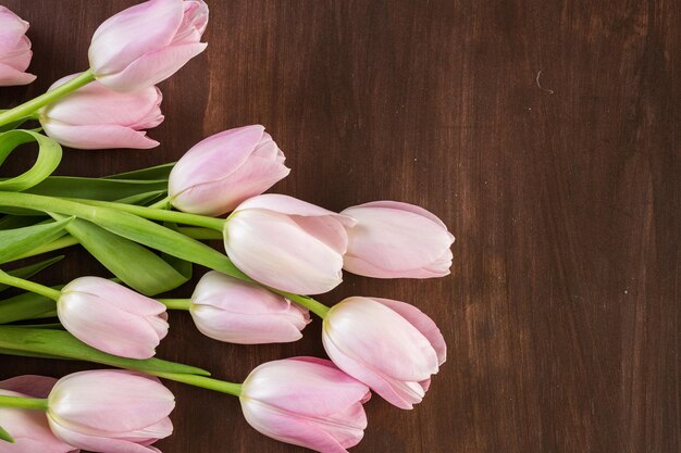 Bouquet of pink tulips on a wood background.