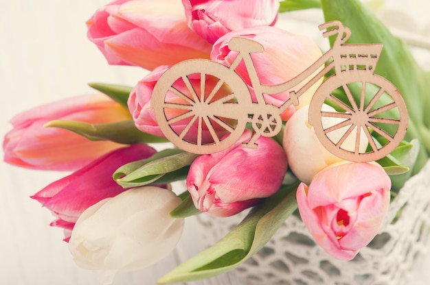 Bouquet of pink tulips and wooden bike