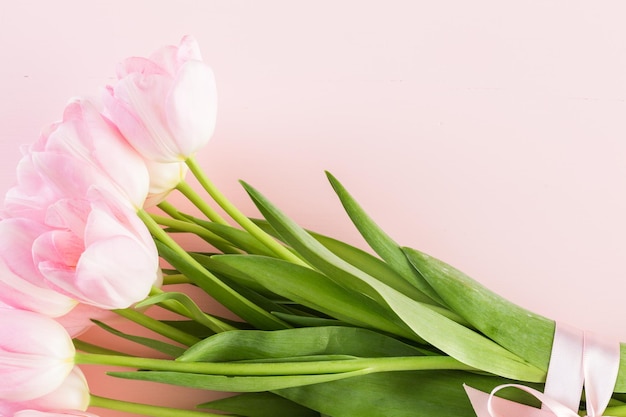 Bouquet of pink tulips wrappen in pink paper.