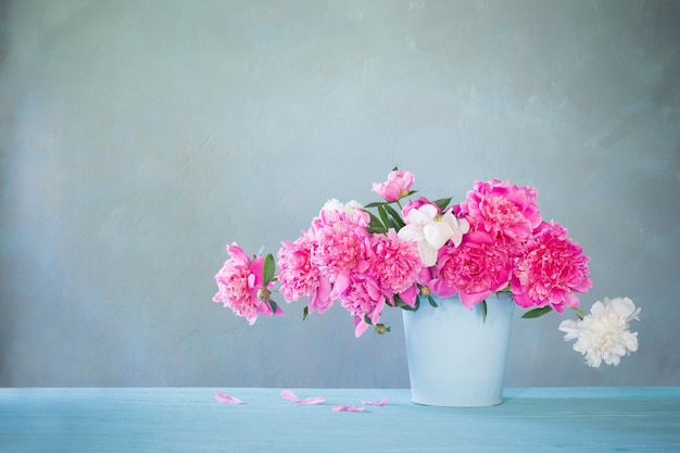 Bouquet of pink and white peonies  on table old wall