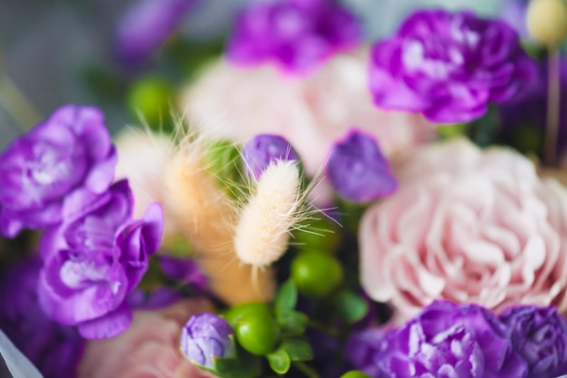 Букет фиолетовых цветов с белым цветком в центре