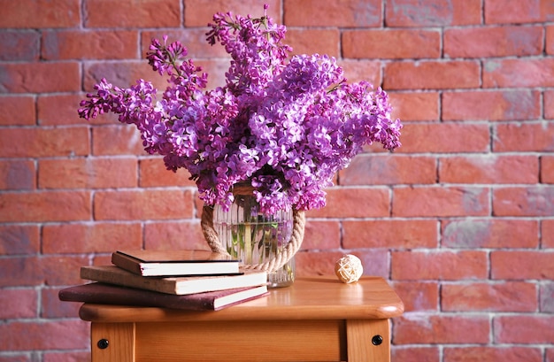 Bouquet of purple lilac flowers on red brick wall background