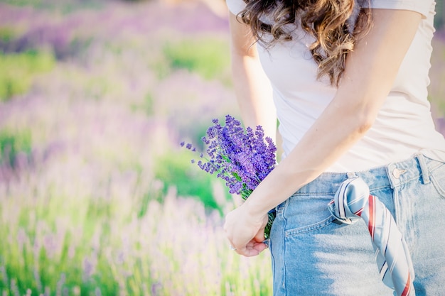 Bouquet of purple violet lavender flowers in the jeans pocket