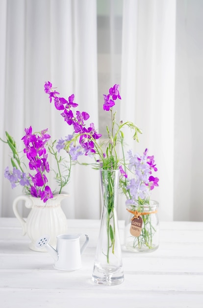 Bouquet of purple wildflowers in a glass vase isolated