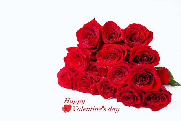 Bouquet of red (burgundy) roses on a white background. Water drops. Congratulations (inscription) on Valentine's Day. Close-up.