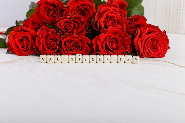 A bouquet of red roses and the inscription on the beads