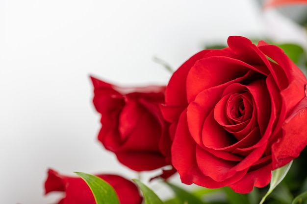 白いテーブルの上の赤いバラの花束
