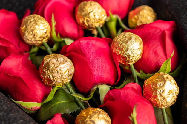 Bouquet of red roses with golden chocolates