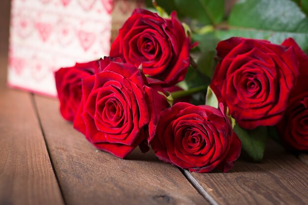 Bouquet of red roses on a wooden table.